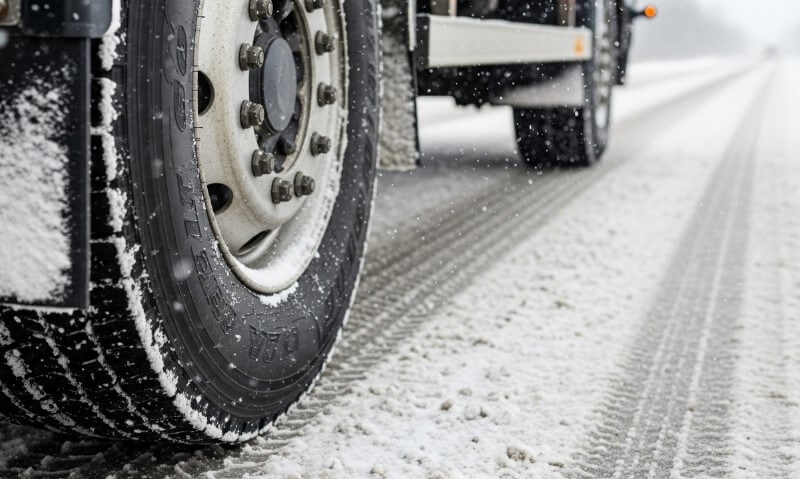 Ein Lastwagen fährt auf einer verschneiten Straße