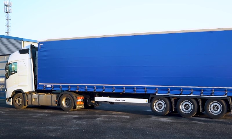Ein großer blauer Lastwagen mit einem weißen Anhänger