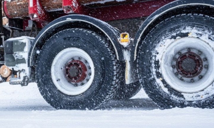 Nahaufnahme eines Lkw-Reifens im Schnee, der die winterlichen Bedingungen und die Textur des Reifens zeigt
